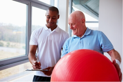 therapist with patient holding swiss ball